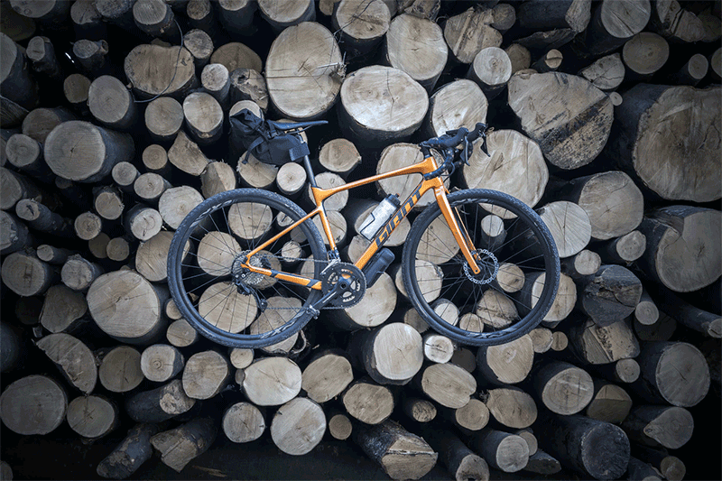 gravel bike on logs stack