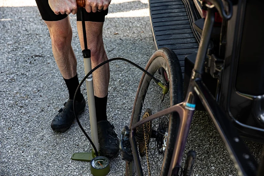 man inflating bike tire with tire pump