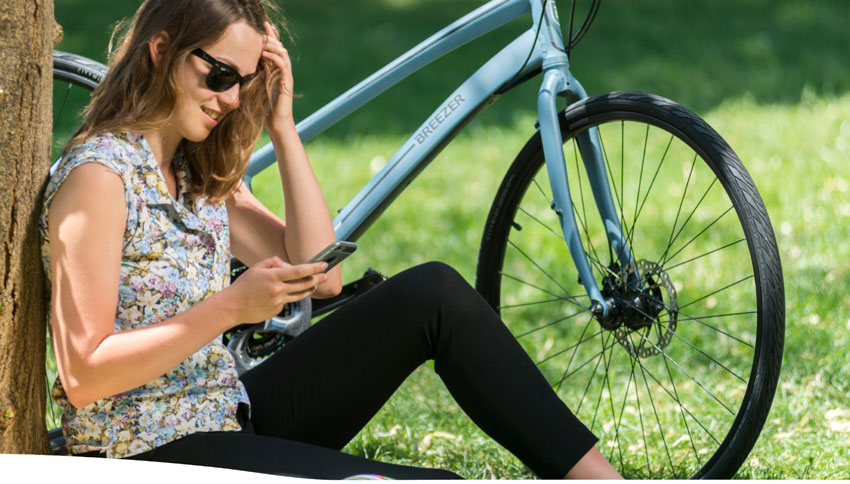woman sitting next to a breezer transportation bike