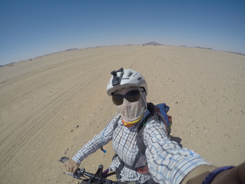 emilie riding through a desert in Soudan
