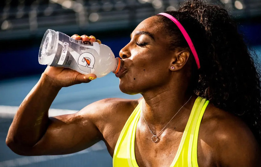 woman cyclist drinking gatorade