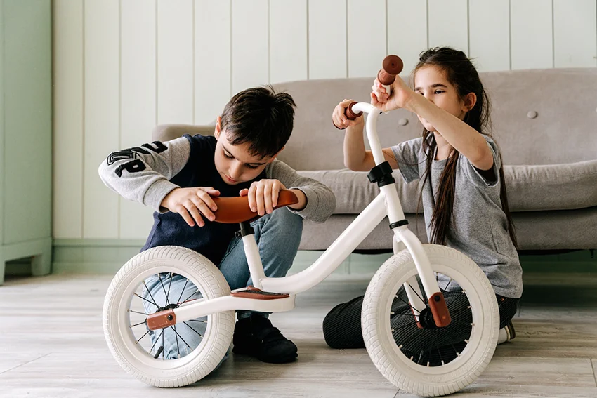 boy and girl adjusting kids bike size