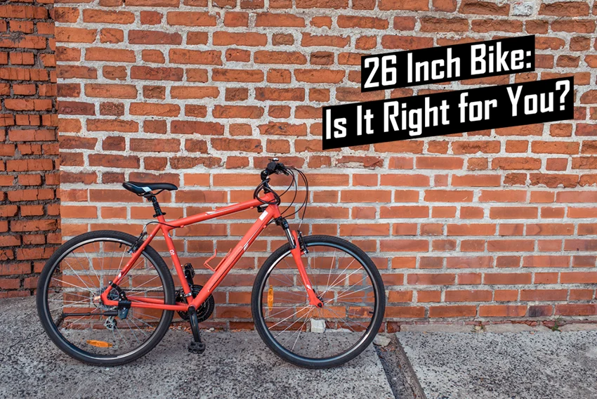 orange 26 inch bike leaned against a brick wall