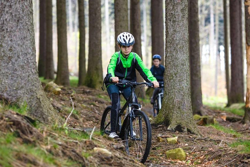 boy riding a 26 inch mountain bike in the forest