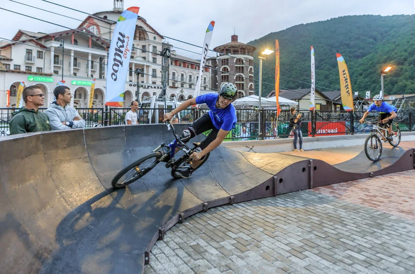 two cyclists riding on pump track bikes