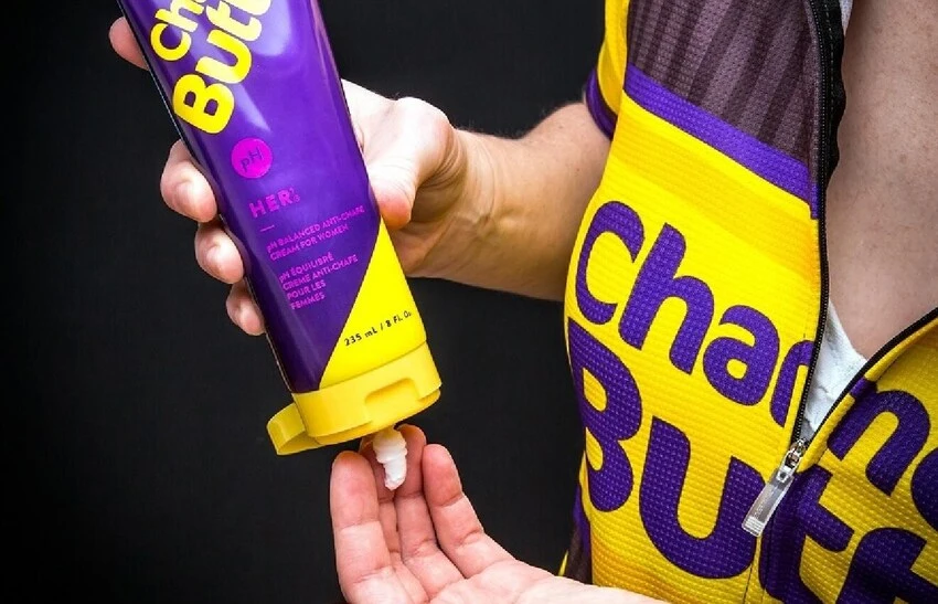 person squeezing chamois cream out of a tube into their hand